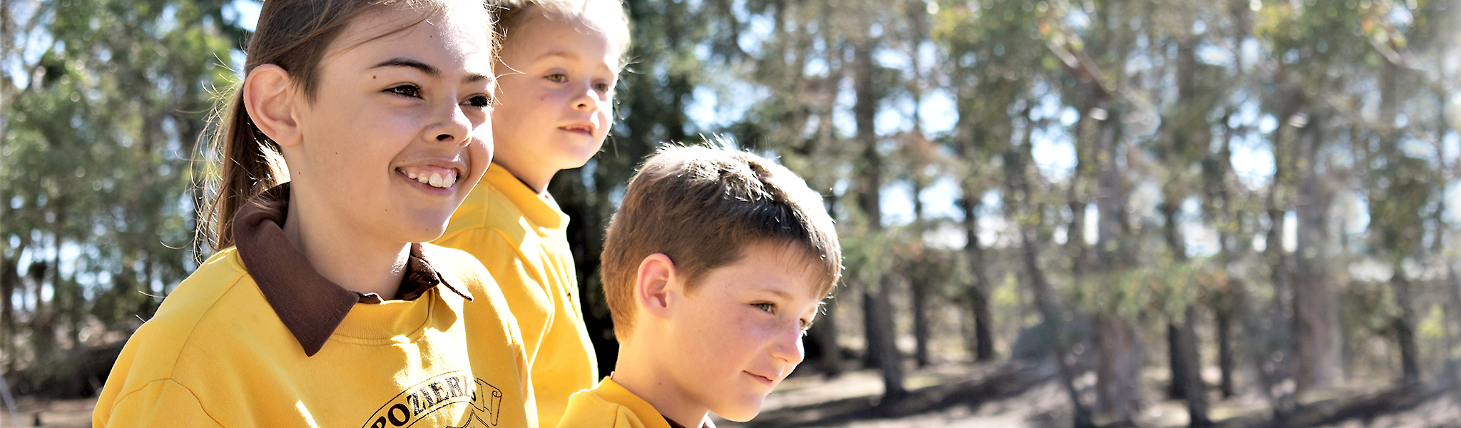 Students in uniform sitting on boulders at Pozieres State School